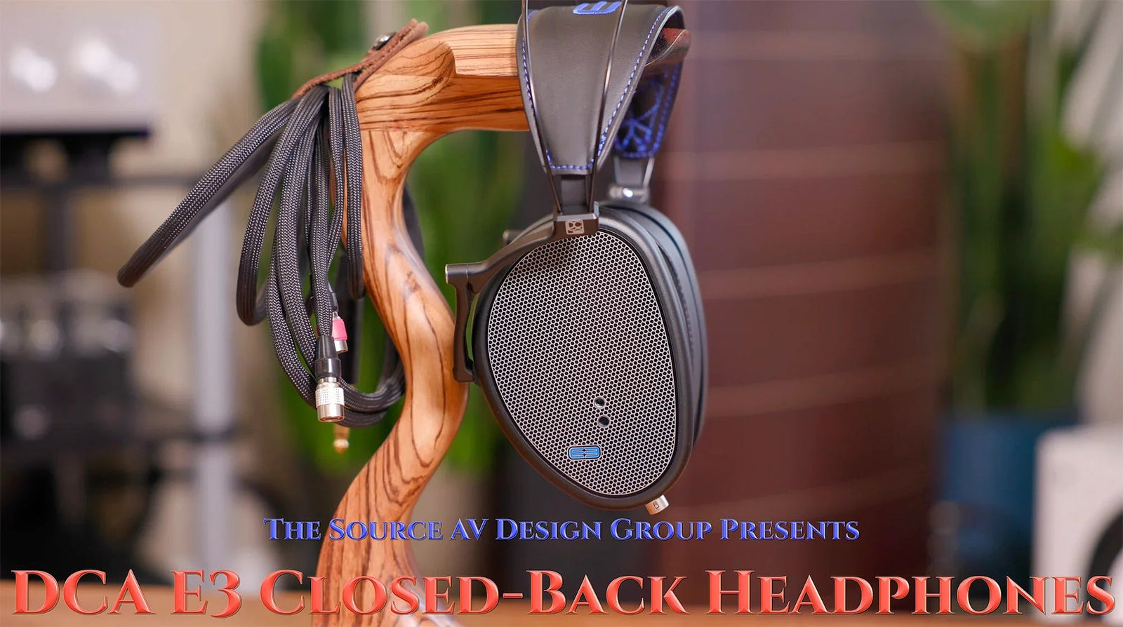 DCA E3 closed-back headphones on wooden stand with braided audio cable at The Source AV.