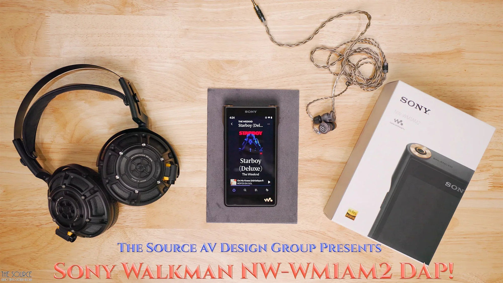 Sony Walkman NW-WM1AM2 digital audio player with headphones, IEMs, and box on wooden table.